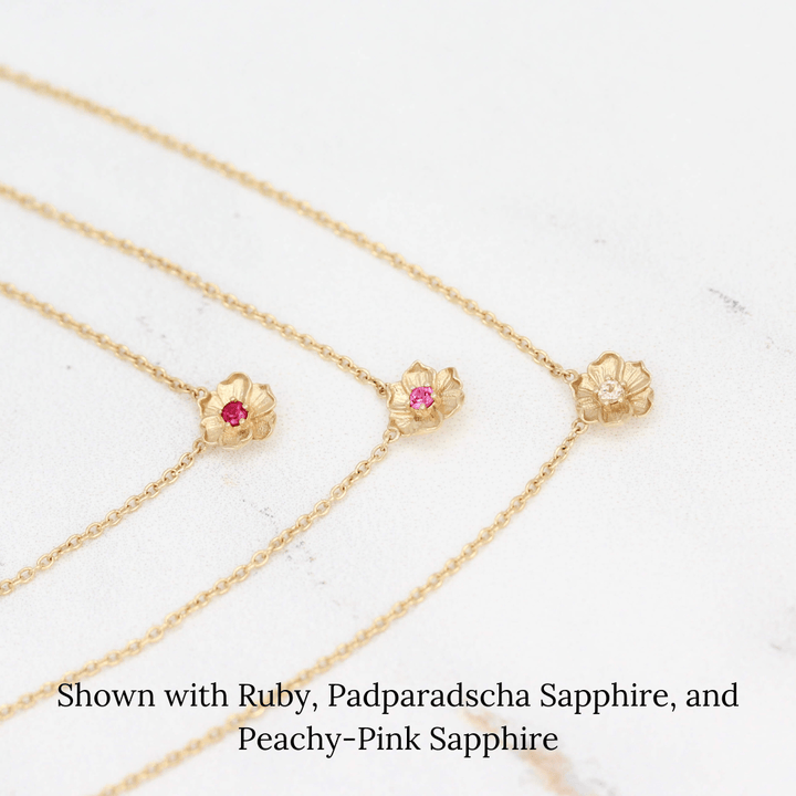 The July Birthstone Poppy Necklace with Ruby in Yellow Gold stacked with the January Birthstone Poppy Necklace with Padparadscha Sapphire in Yellow Gold and the October Birthstone Poppy Necklace with Peachy-Pink Sapphire in Yellow Gold against a white background