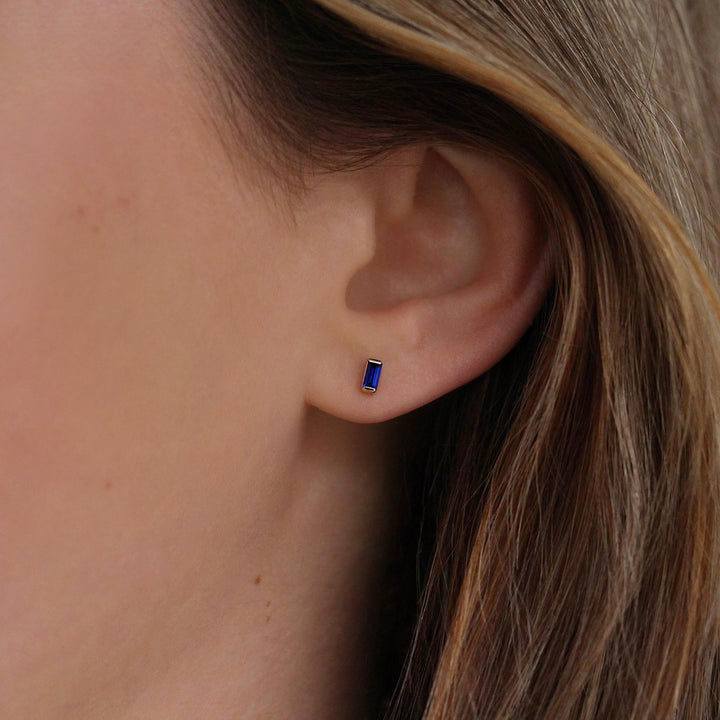 The September Baguette Birthstone Earrings with Blue Sapphire in Yellow Gold modeled