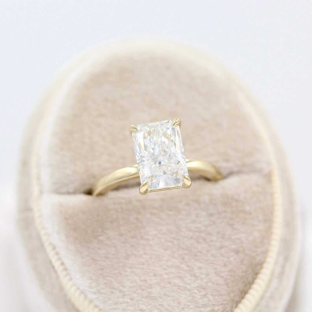 The Celeste Ring (Radiant) in Yellow Gold in a tan velvet ring box