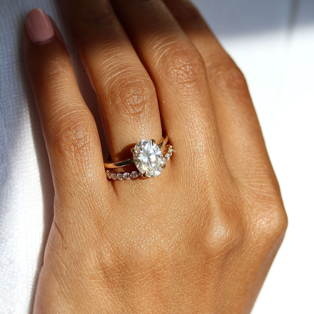 The Celeste Ring in Yellow Gold stacked with the Carly wedding band in yellow gold modeled on a hand