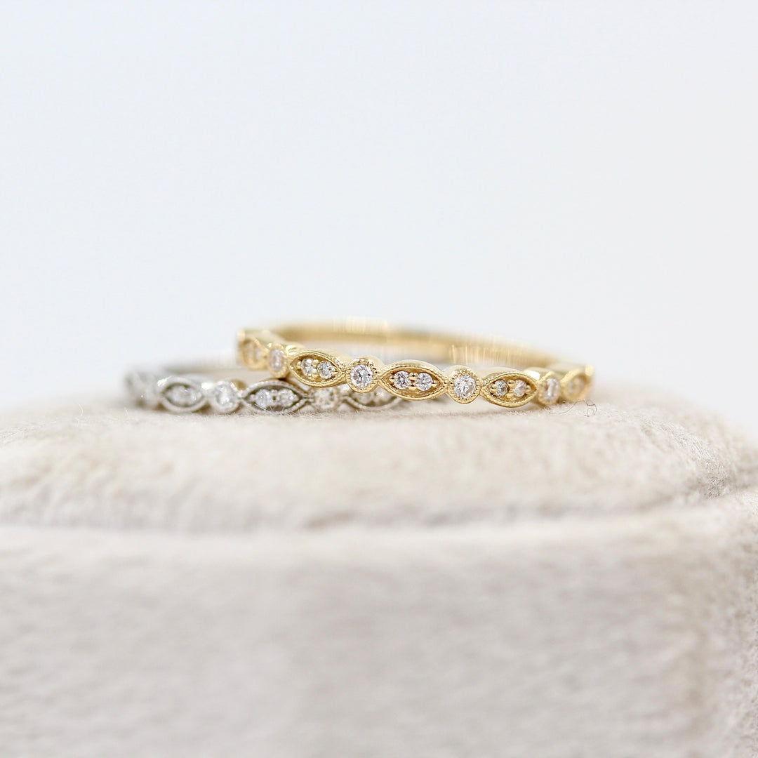 The Charlotte Wedding Band in Yellow Gold and The Charlotte Wedding Band in White Gold stacked on a ring box