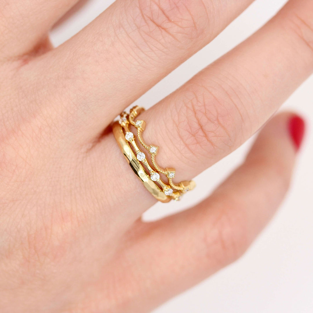 The Christie Bands in yellow gold stacked with the Sloane wedding band in yellow gold modeled on a hand