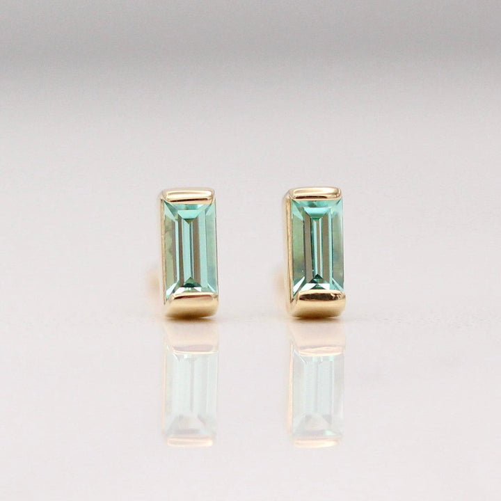 The August Baguette Birthstone Earrings with Chrysoberyl in Yellow Gold against a white background