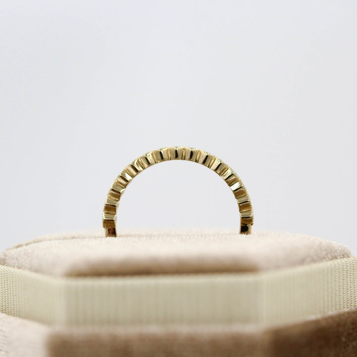 The August Florence Birthstone Wedding Band with Chrysoberyl in Yellow Gold in a brown velvet ring box