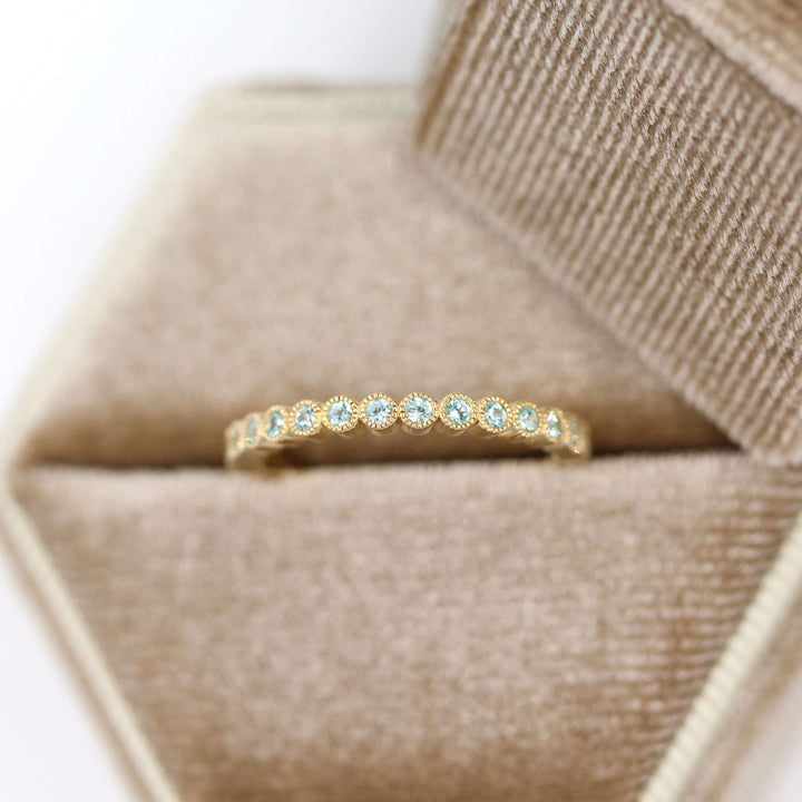 The August Florence Birthstone Wedding Band with Chrysoberyl in Yellow Gold in a brown velvet ring box