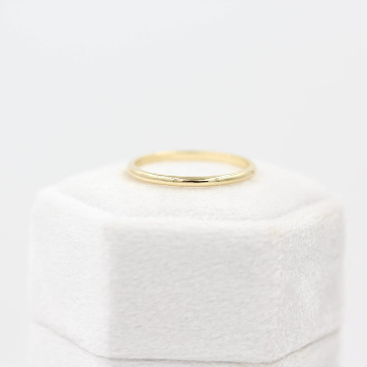 Classic Stacking Band in Yellow Gold atop a white velvet ring box