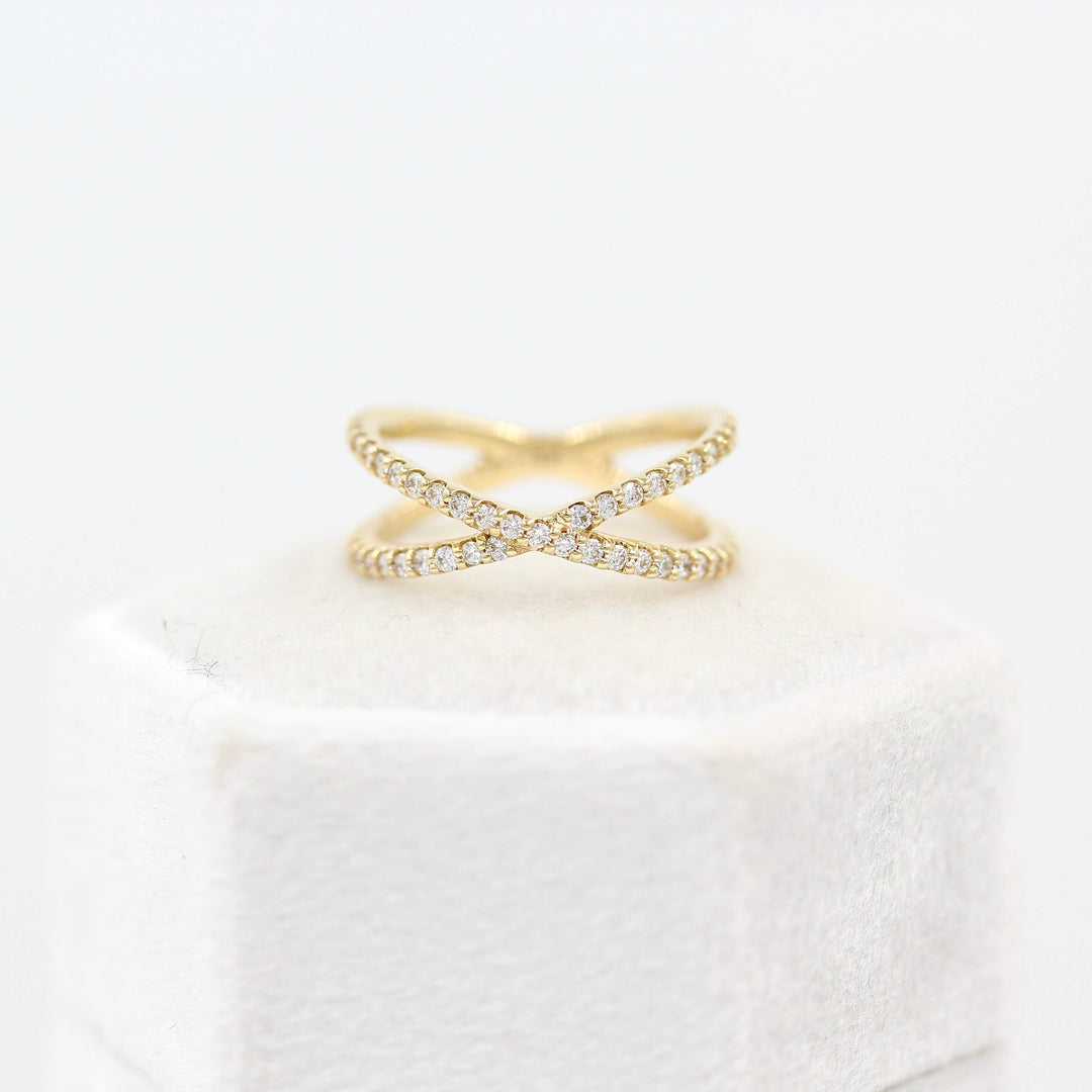 The Criss Cross ring in yellow gold atop a white velvet ring box