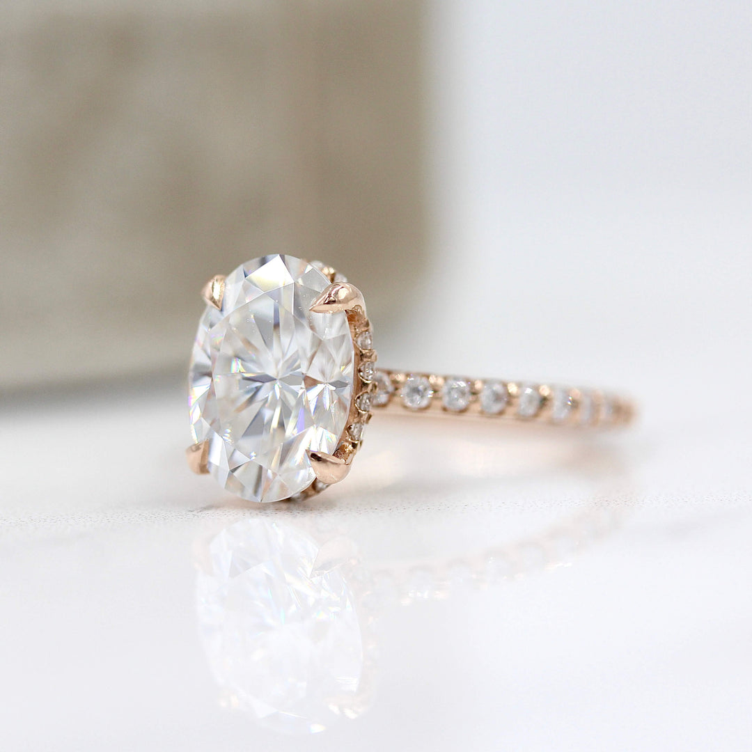 The Athena Hidden Halo Ring (Oval) in Rose Gold and Moissanite in front of a ring box