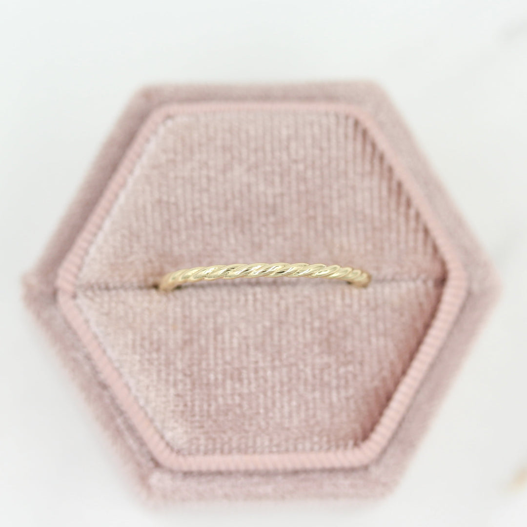 Dainty gold twist stacking band in a rose-colored velvet ring box