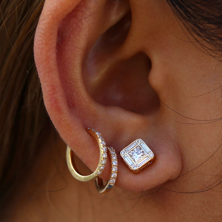 The Darby Earrings in Yellow Gold modeled on an ear with the 12mm and 14mm Diamond Huggies in yellow gold