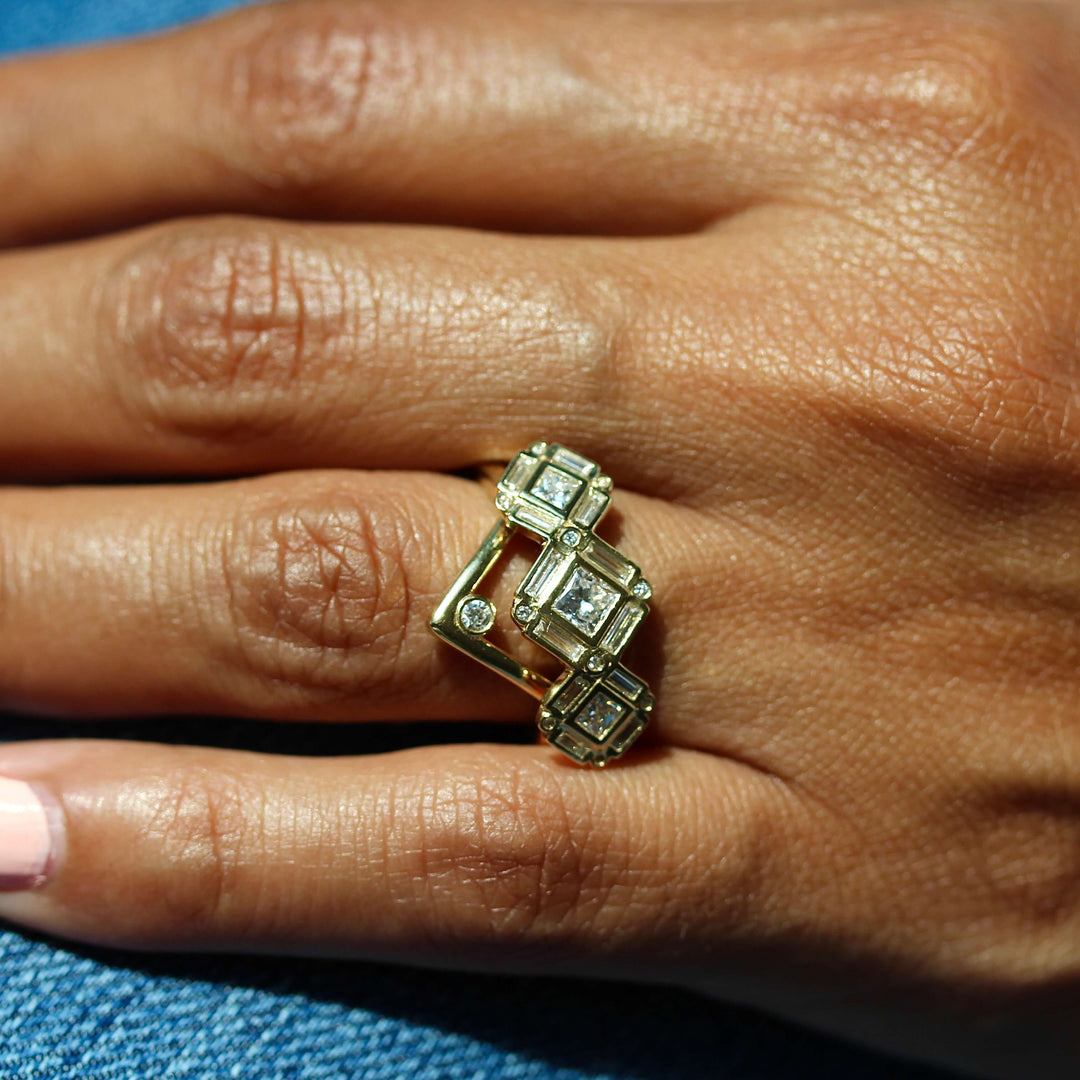 The Darby Ring in Yellow Gold stacked with the Single Diamond V-Band in yellow gold modeled on a hand