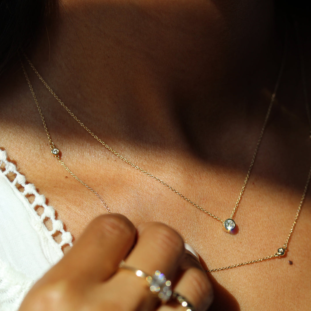 Round lab grown diamond bezel necklace modeled with diamond station necklace