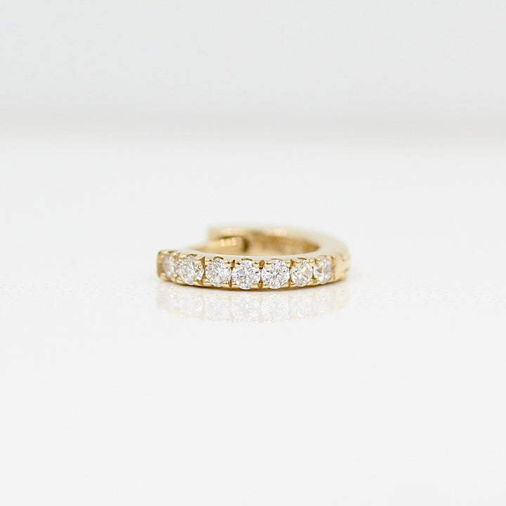 A 10mm single Diamond Huggie in Yellow Gold against a white background