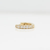 A 10mm single Diamond Huggie in Yellow Gold against a white background