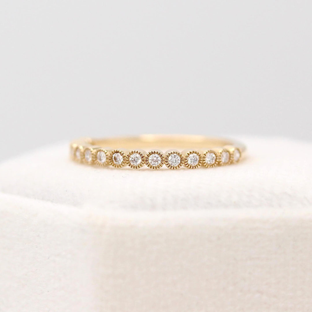 The April Florence Birthstone Wedding Band with Lab-Grown Diamond in Yellow Gold atop of a white velvet ring box