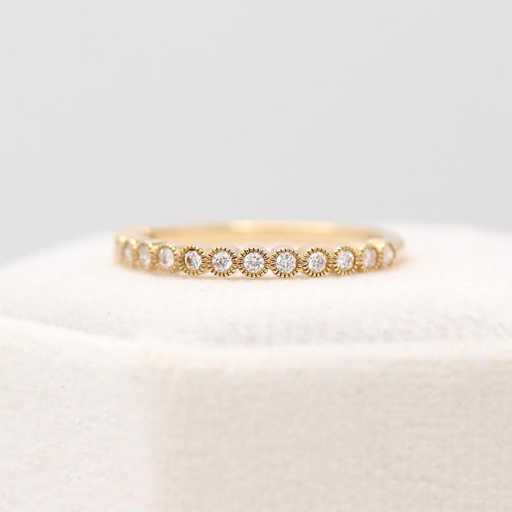 The April Florence Birthstone Wedding Band with Lab-Grown Diamond in Yellow Gold atop of a white velvet ring box