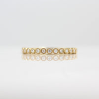 The April Florence Birthstone Wedding Band with Lab-Grown Diamond in Yellow Gold against a white background