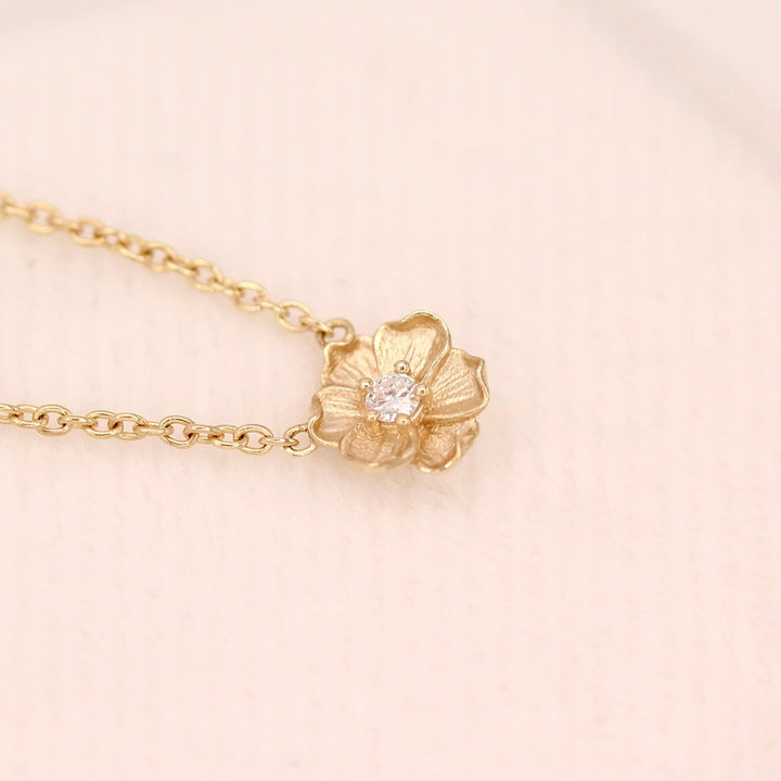 The April Birthstone Poppy Necklace with Lab-Grown Diamond in Yellow Gold atop of a white velvet ring box