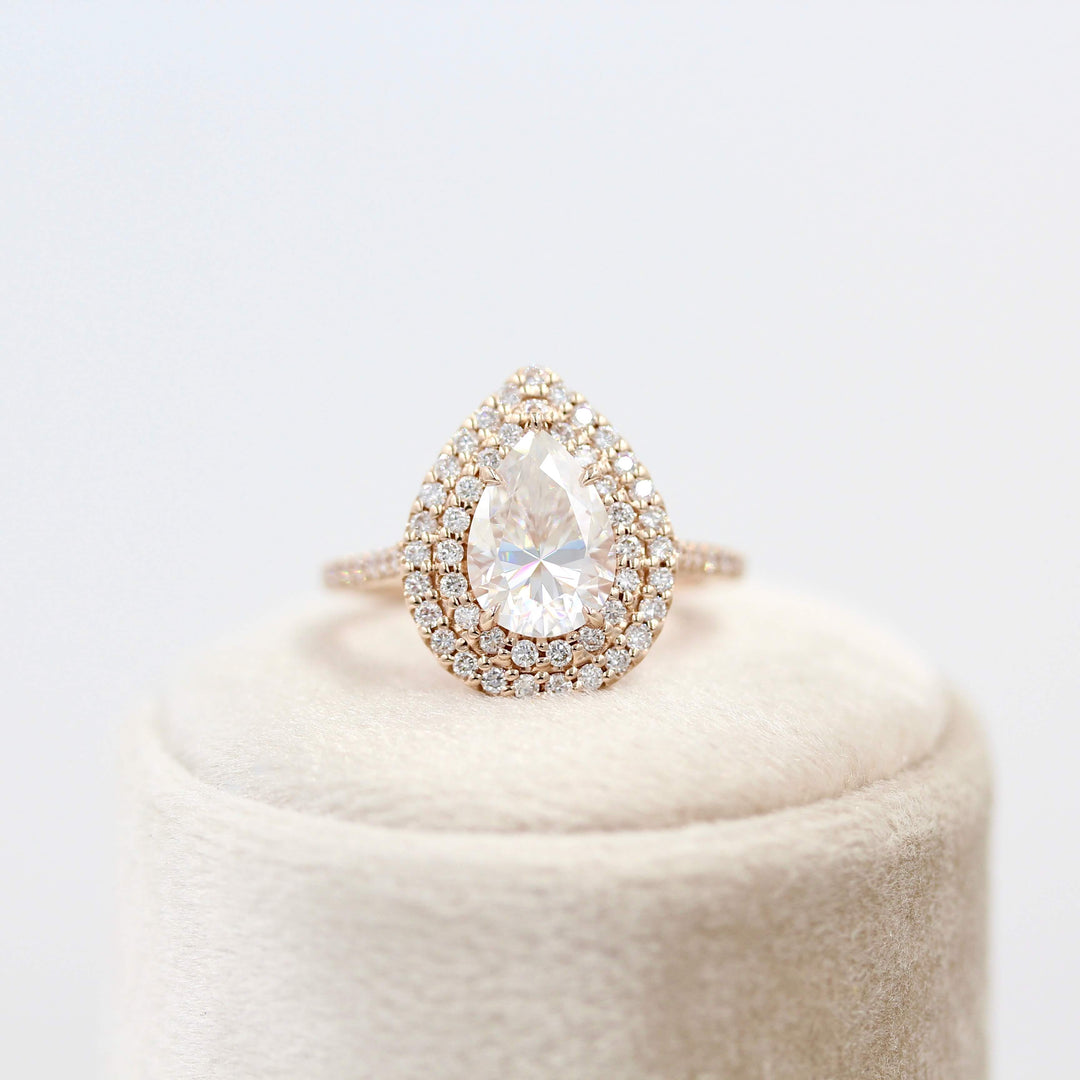 The Double-Halo Carly Ring in Rose Gold atop a white velvet ring box