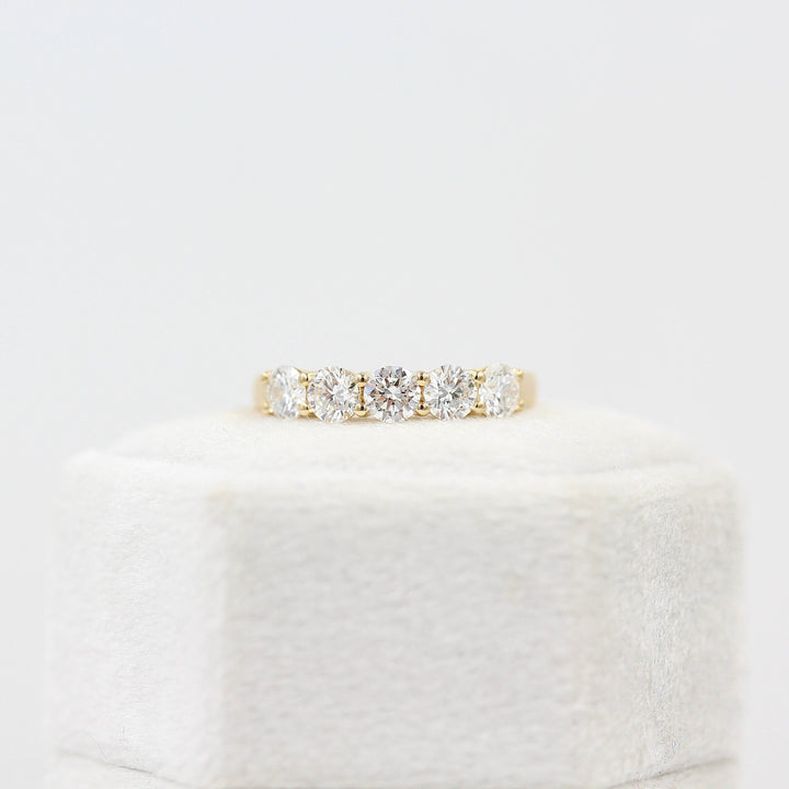 The Elisa Wedding Band in Yellow Gold with 1.25ct Lab-Grown Diamond atop of a white velvet ring box