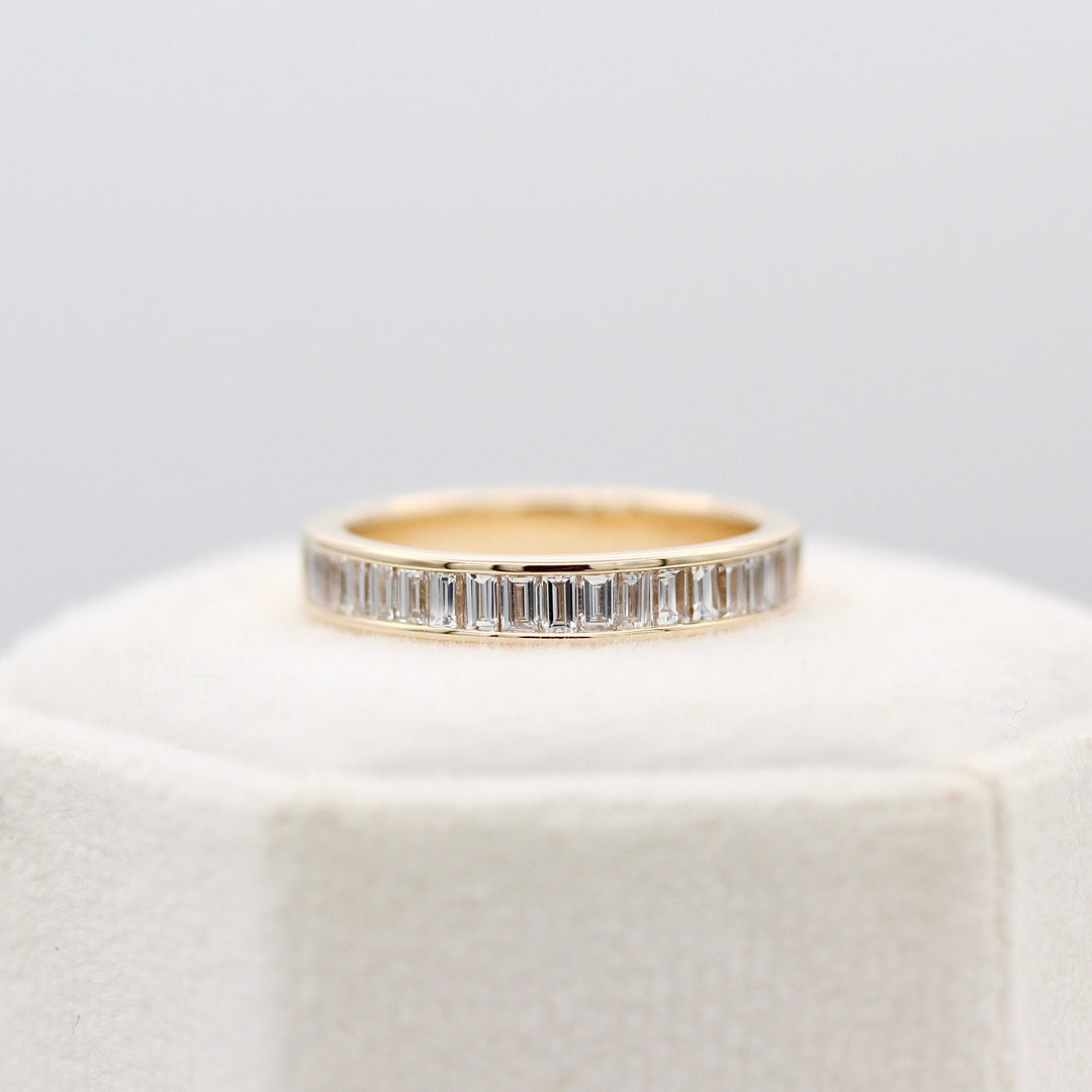 Elle yellow gold baguette diamond ring on top of a white velvet ring box.