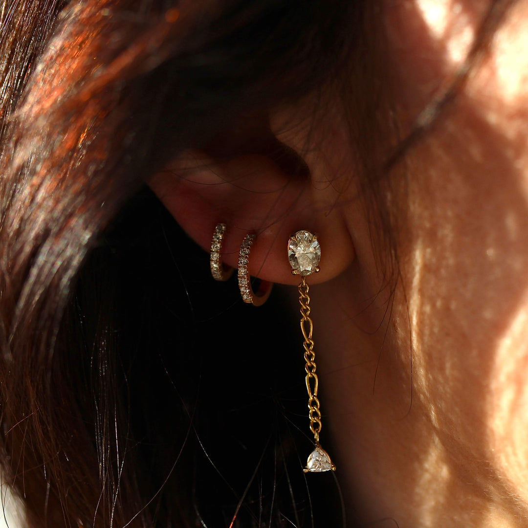 The Emilia Earrings in yellow gold modeled with two of the Diamond Huggies in yellow gold