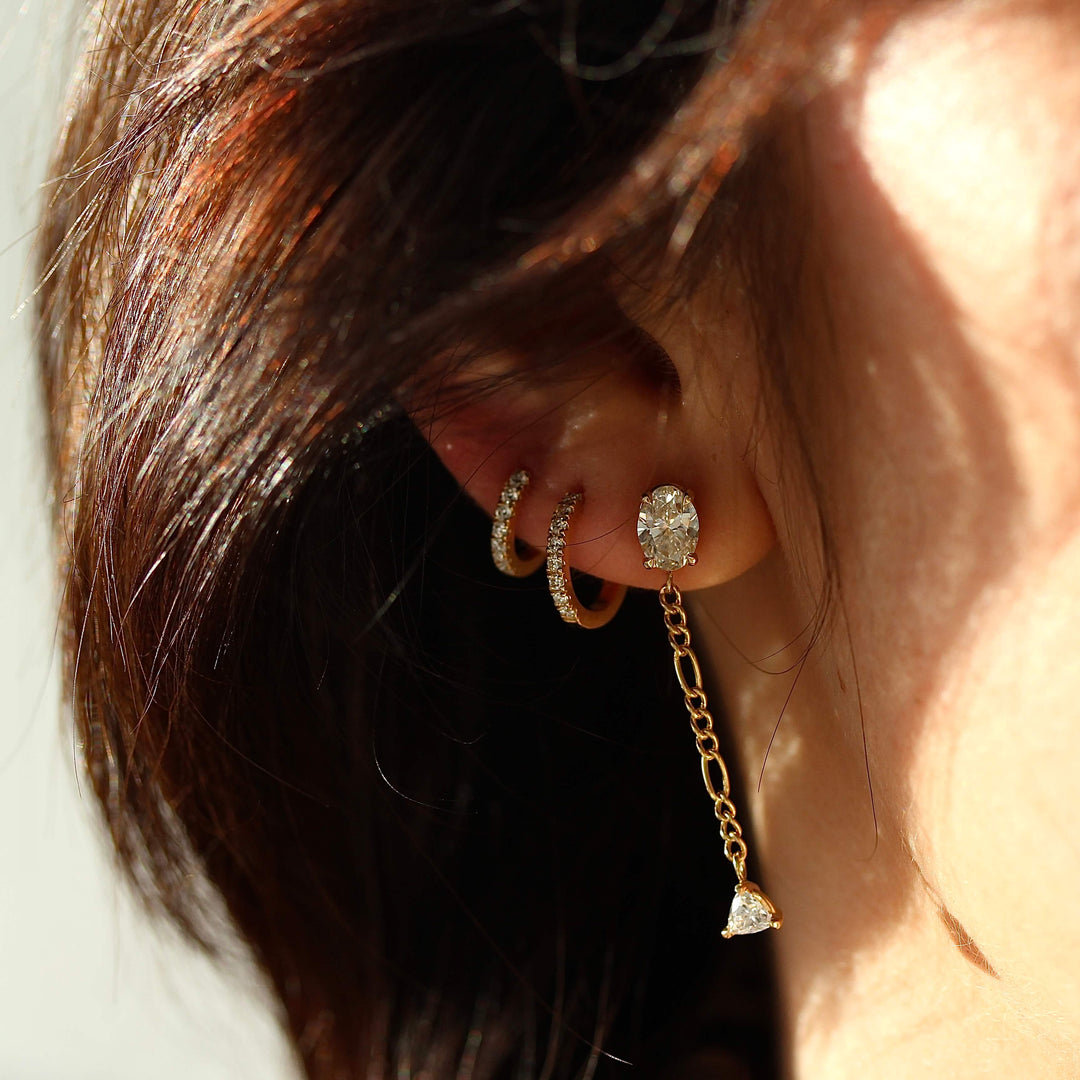 The Emilia Earrings in yellow gold modeled with two of the Diamond Huggies in yellow gold