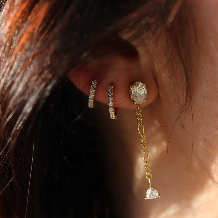 The Emilia Earrings in yellow gold modeled with two of the Diamond Huggies in yellow gold