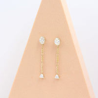 The Emilia Earrings in yellow gold in a pink triangular piece of foam