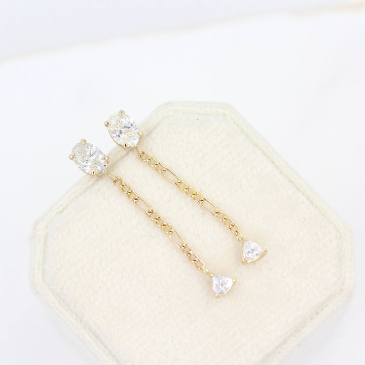The Emilia Earrings in yellow gold atop a white velvet ring box