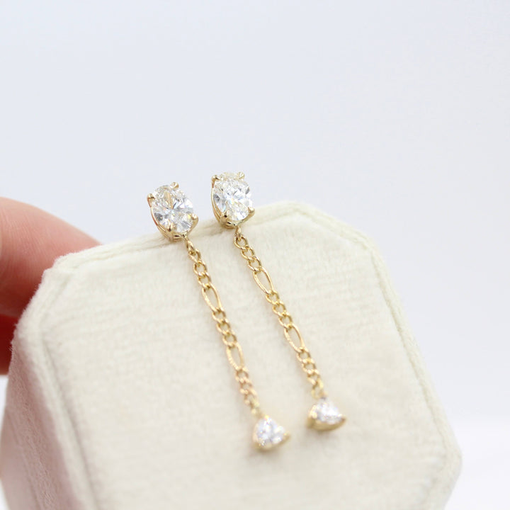 The Emilia Earrings in yellow gold atop a white velvet ring box