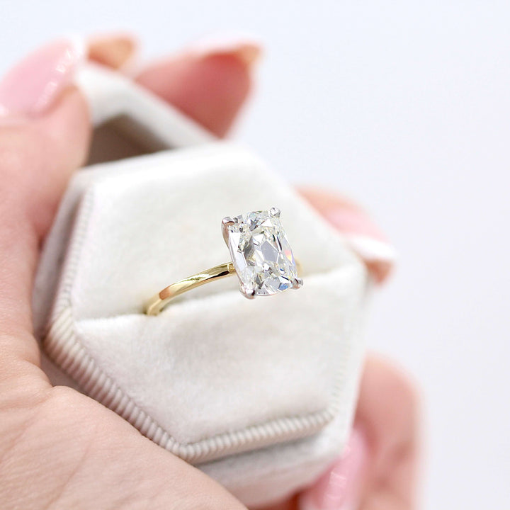 The Eri Ring in Platinum and 18k Yellow Gold with a 3ct Lab Grown Diamond in a white velvet ring box held by a hand