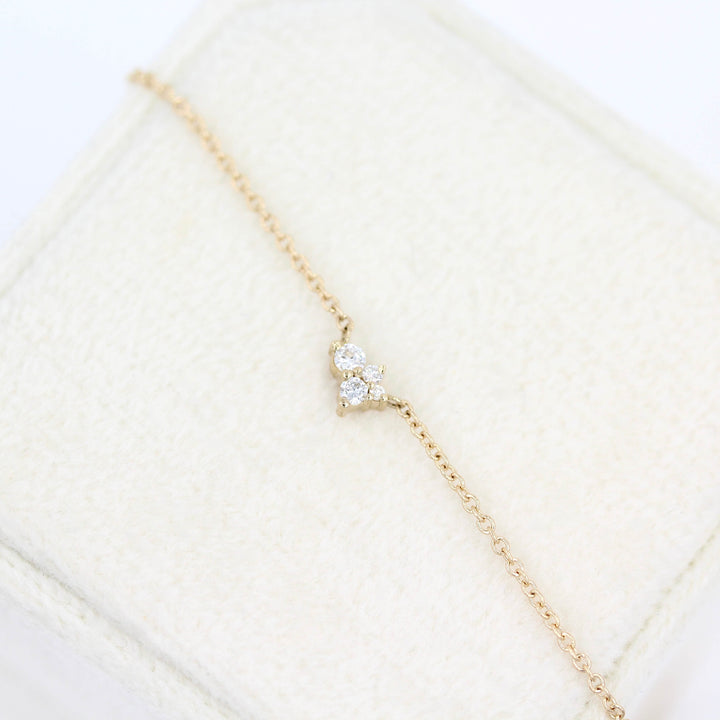 The Felicity Necklace in yellow gold atop a white velvet ring box