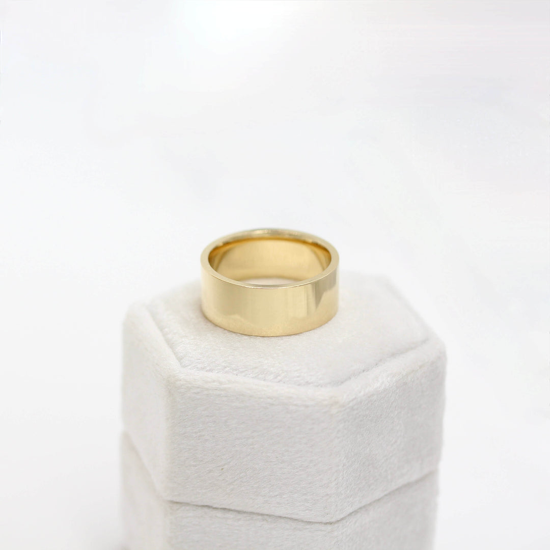 Flat Men's Band/Unisex Band in Yellow Gold atop a irng box