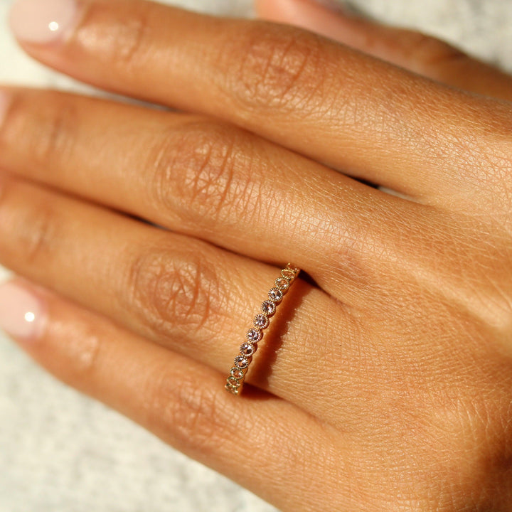 The October Florence Birthstone Wedding Band with Peachy-Pink Sapphire in Yellow Gold modeled