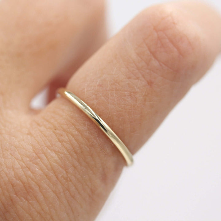 Gold stacking band worn alone on an index finger