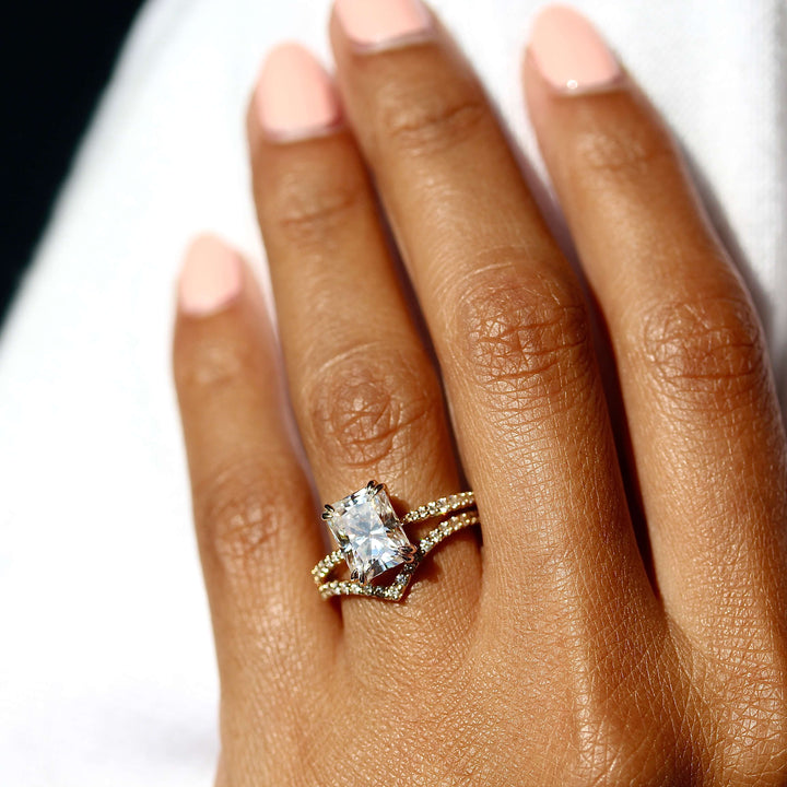 The Grace Ring (Emerald) in Yellow Gold stacked with the Diamond V-Band in yellow gold modeled on a hand