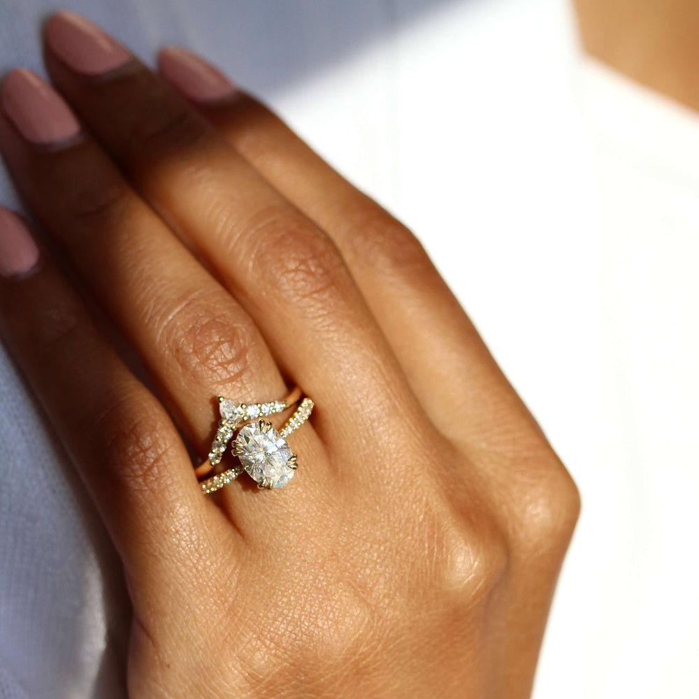 The Grace Ring (Oval) in Yellow Gold stacked with the Pinnacle wedding band modeled on a hand