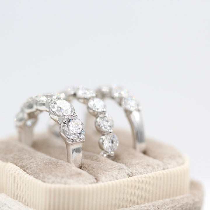 The Greta, Melody, and Elisa wedding bands in white gold in a white velvet ring box