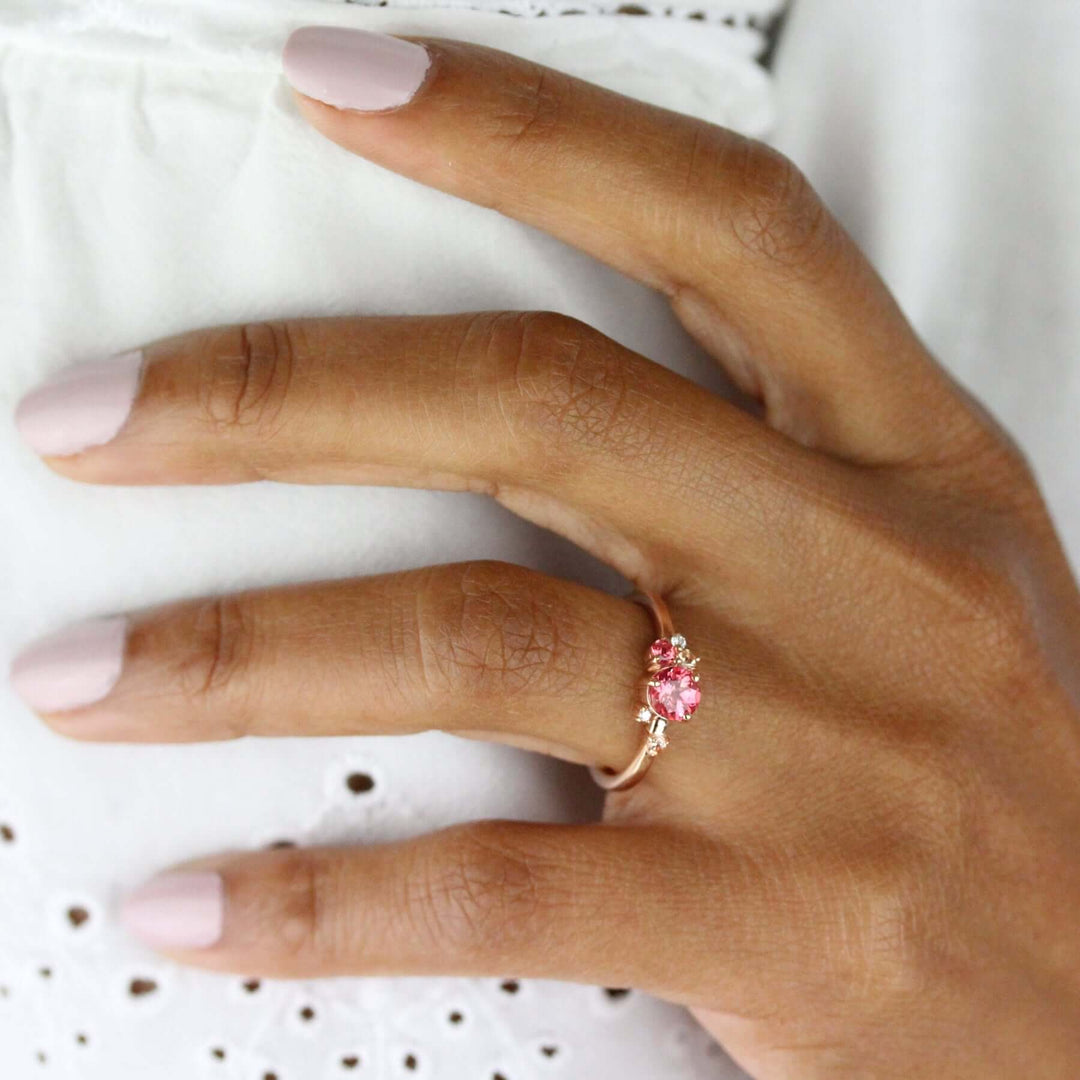 Pink sapphire ring on brown-skin hand with pink nail polish