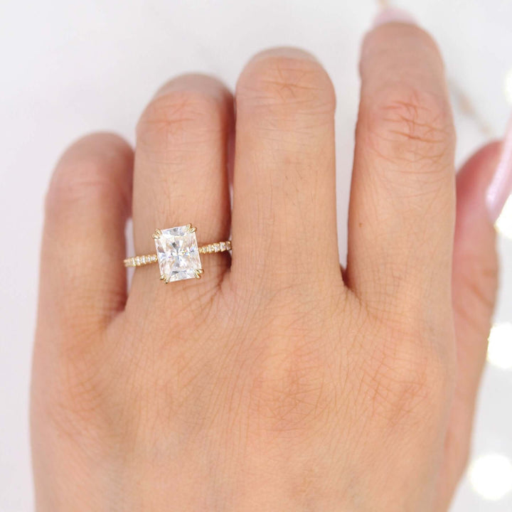 Hand wearing radiant moissanite engagement ring