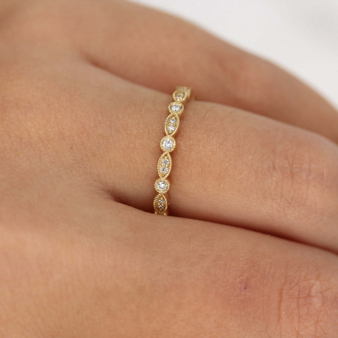 Hand wearing vintage-style wedding band with round and marquise lab grown diamonds