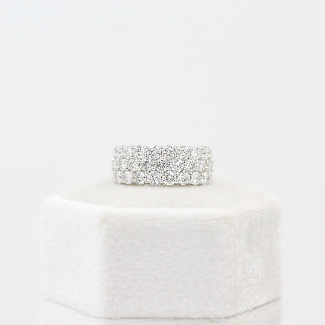 The Harmony Wedding Band in White Gold atop a white velvet ring box