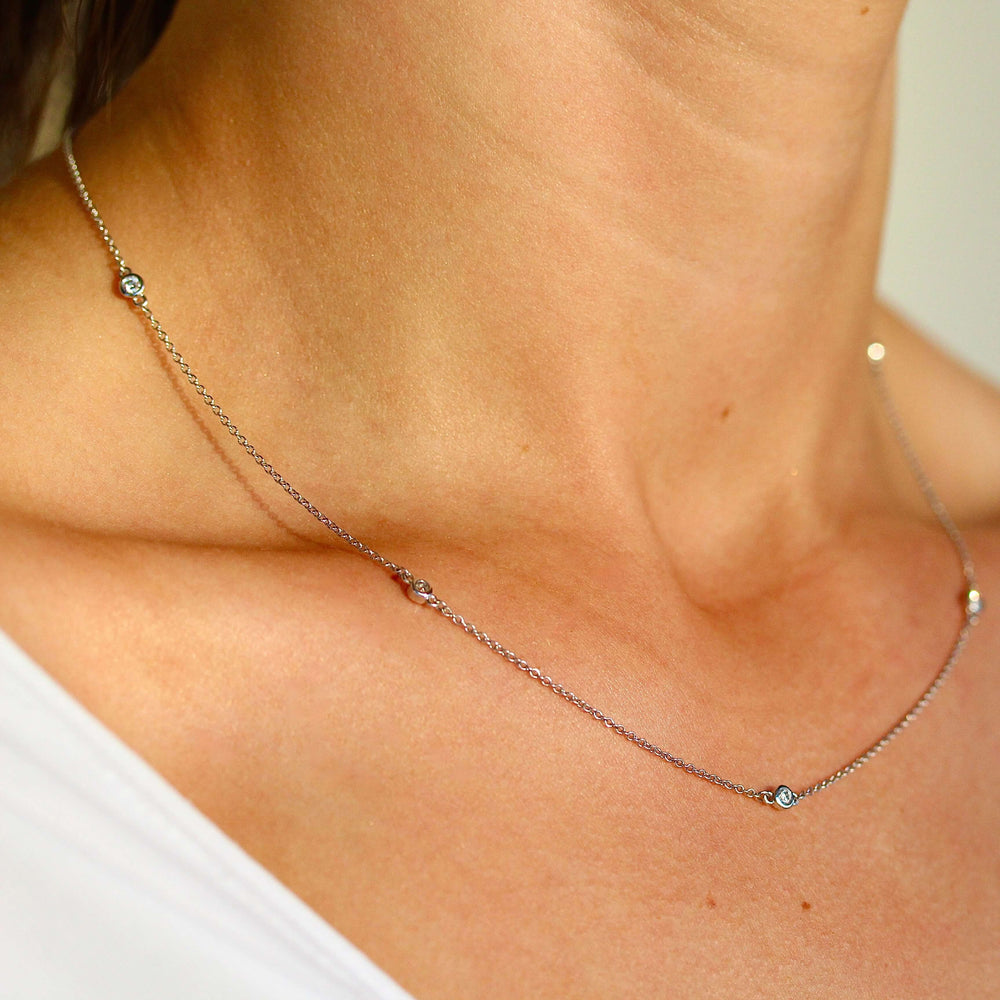 The Diamond Station Necklace in white gold modeled on a neck