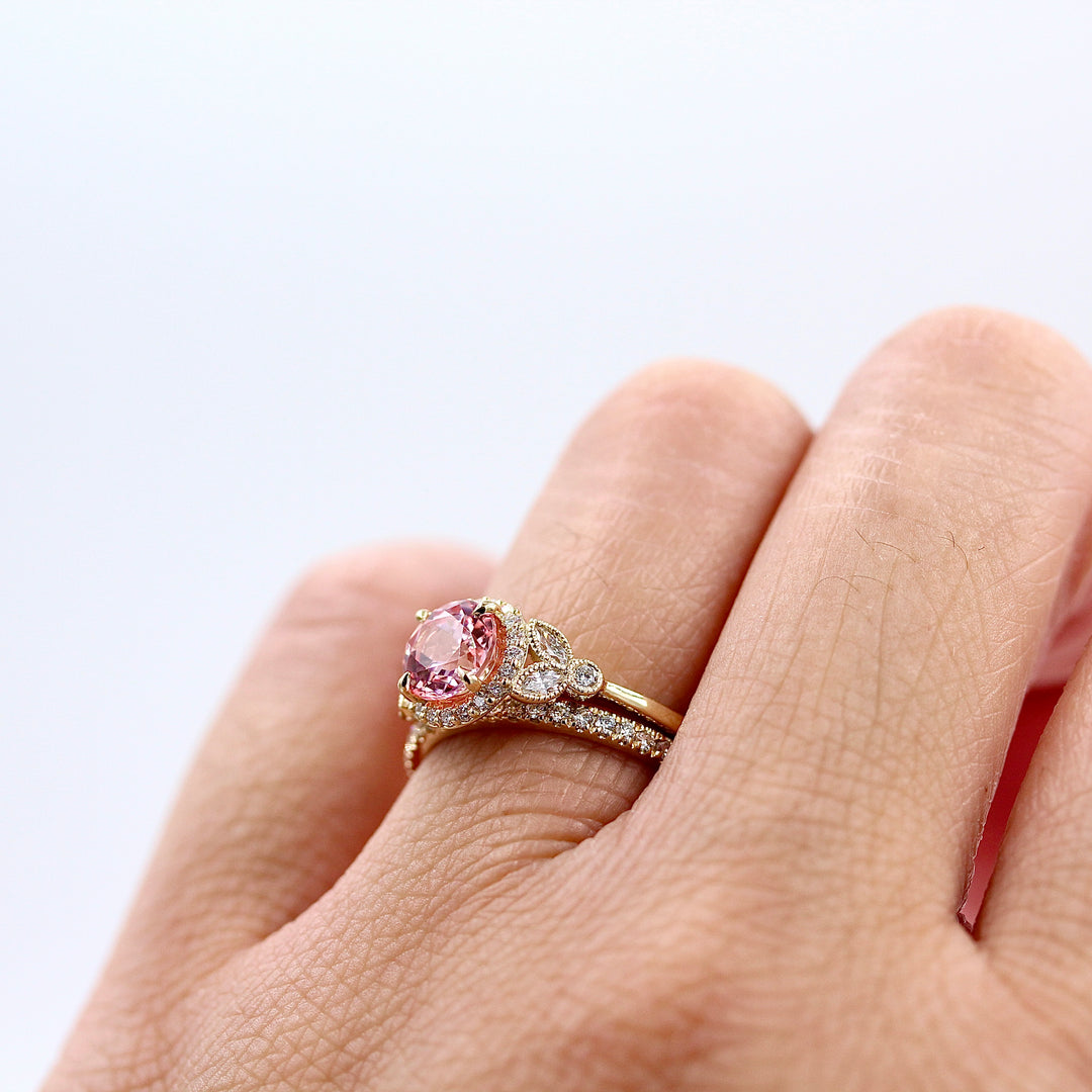 The Cate ring (round) with peachy-pink sapphire in yellow gold modeled with the Elizabeth wedding band in yellow gold on a hand
