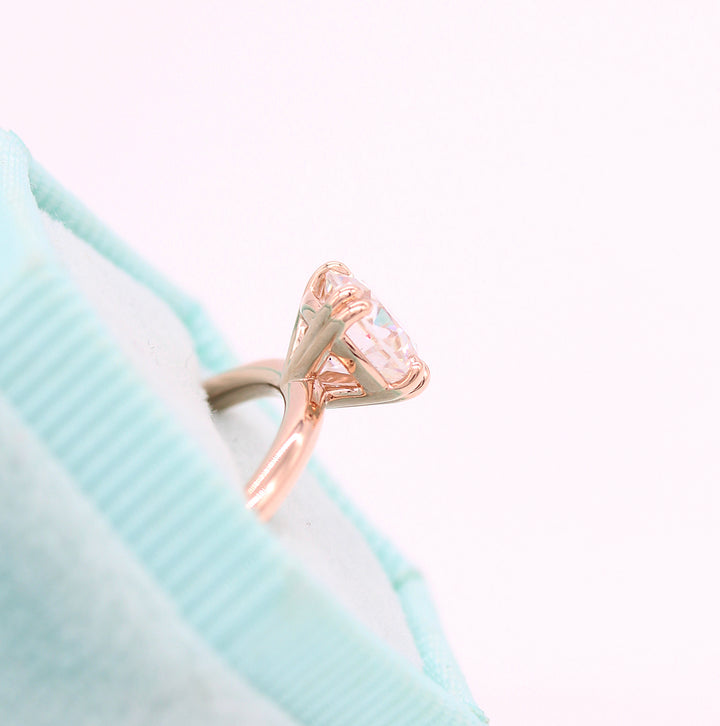 The Serena ring round in rose gold in a blue velvet ring box