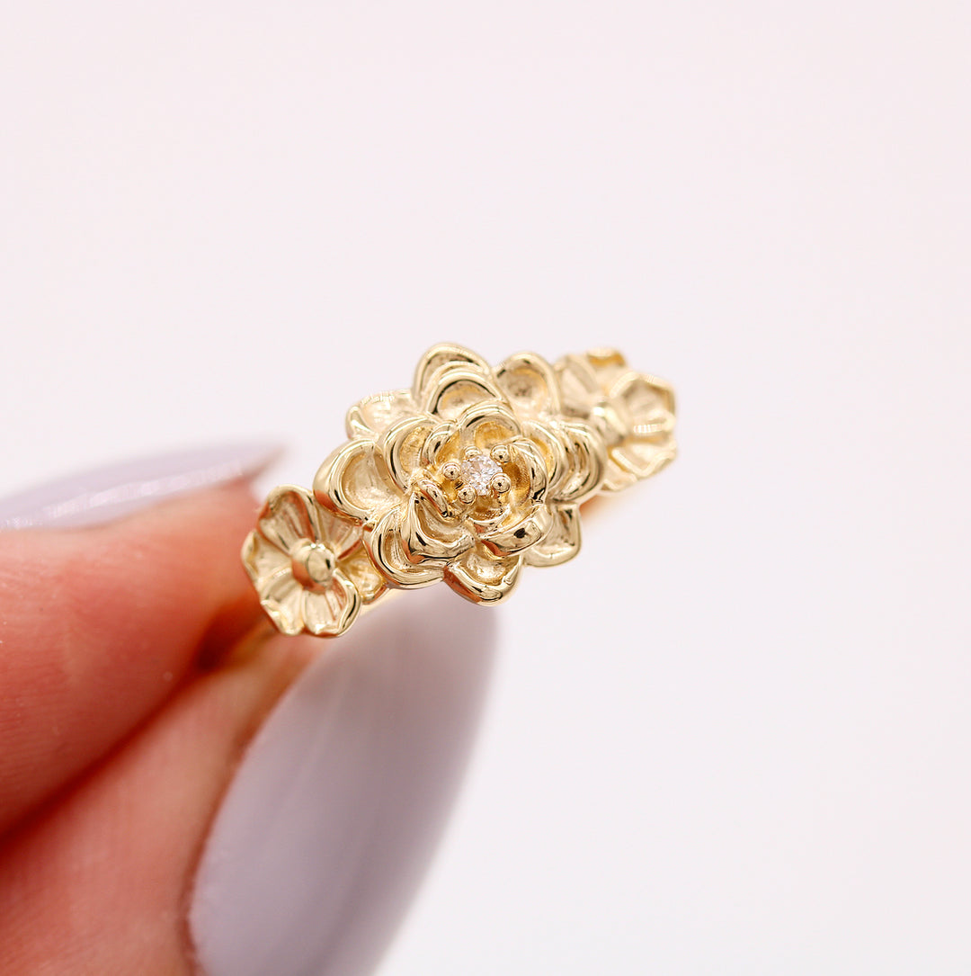 The Posy ring in yellow gold held by a hand