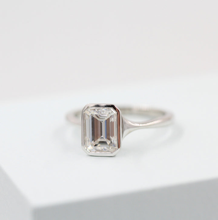 Emerald cut moissanite bezel engagement ring