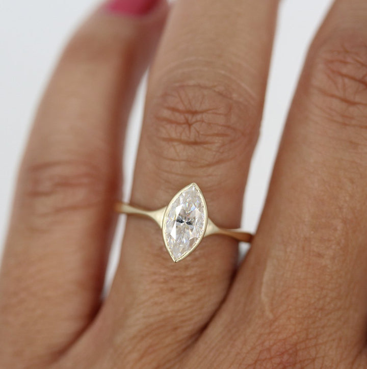 Marquise yellow gold solitaire on a ring finger