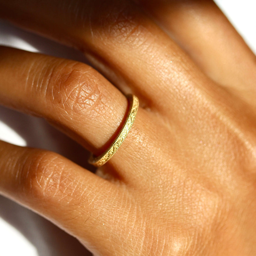 The Sabrina Wedding Band in yellow gold modeled on a hand